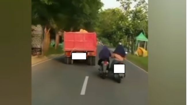 Emak-emak sambil dorong motor rekannya yang mogok dan salip truk di jalan (Instagram)